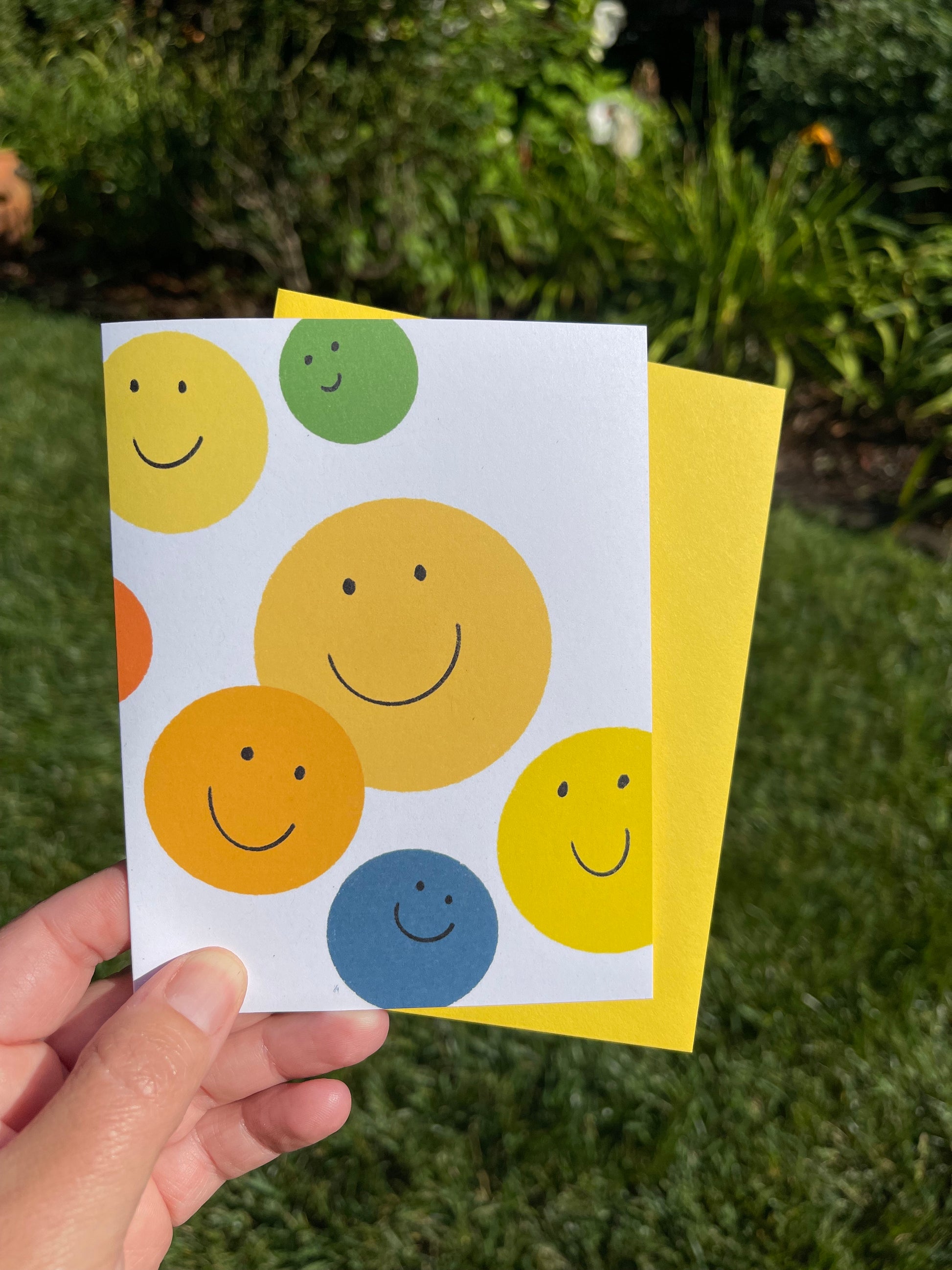 yellow, green, blue and orange smile faces on a greeting card, blank inside