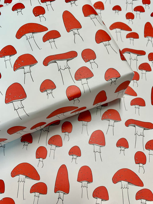 Wrapping paper with red mushrooms in a repeated pattern