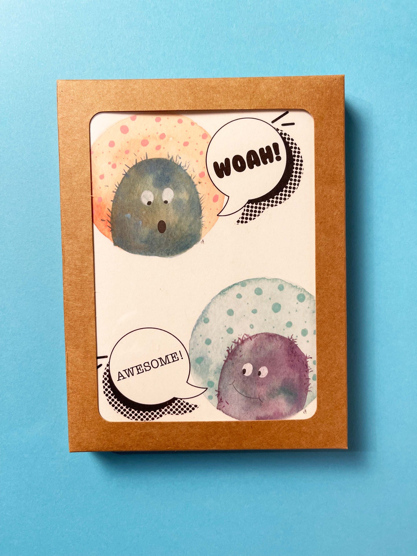 greeting card with illustrated monsters that say Woah! and Awesome. Blank inside, shown as a boxed set