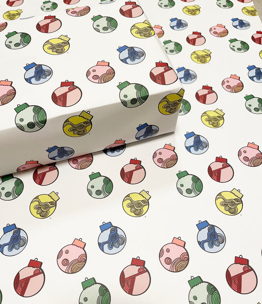 christmas tree balls, red, yellow, green, blue on wrapping paper