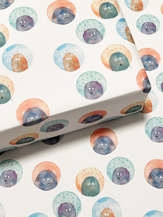 wrapping paper that has a monsters on it making funny faces
