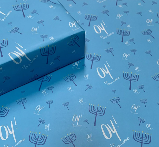 Hanukkah wrapping paper with menorahs and oy to the world wording, blue background color
