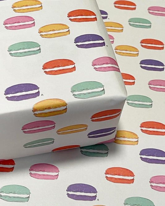 pink, purple, mint, orange and yellow colored macarons on wrapping paper