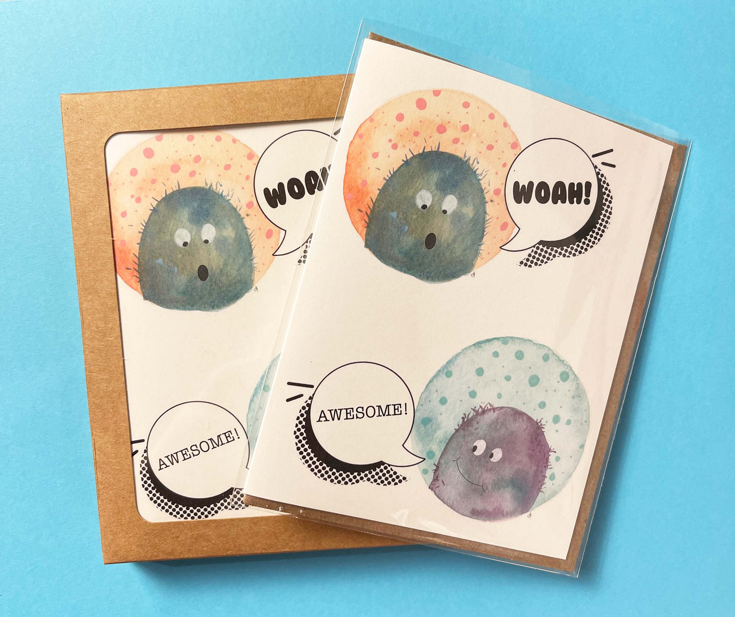 greeting card with illustrated monsters that say Woah! and Awesome. Blank inside. Shown as single card and a boxed set