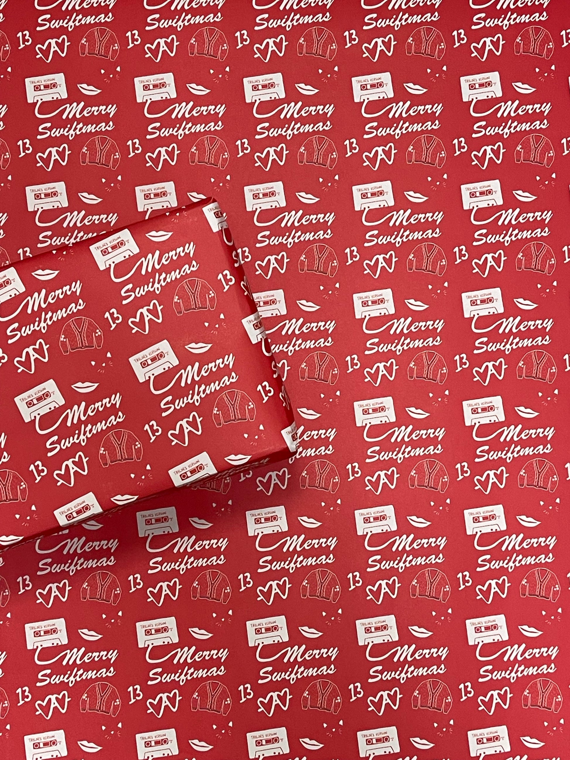 Wrapping paper that reads merry swiftmas with taylor swift inspired icons in white on a red background.