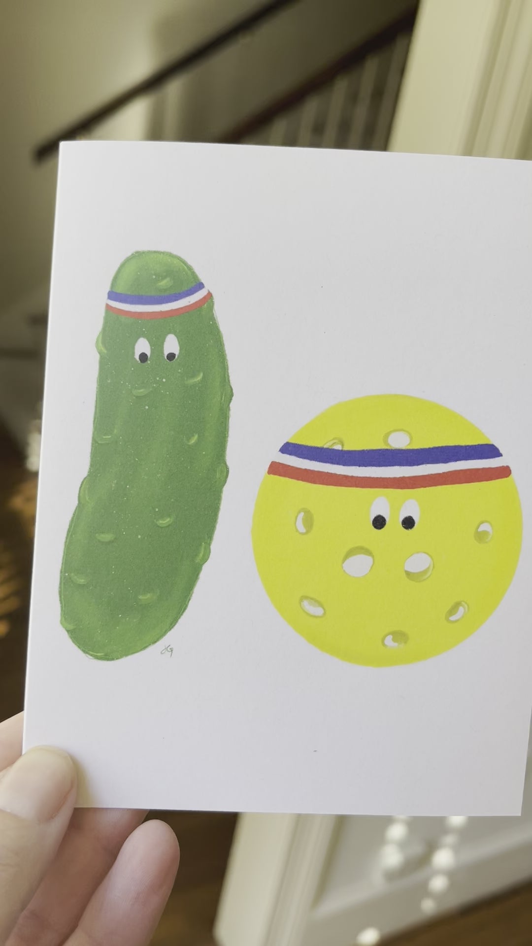 greeting card with a pickle and a ball with sweatbands around their hands. A pun on pickle ball